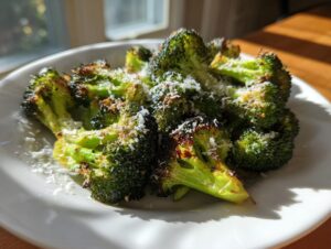 Close-up of bright green, crispy roasted broccoli florets topped with grated Parmesan cheese.