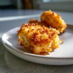 Close-up of perfectly golden, crispy homemade chicken nuggets on a light-colored plate.