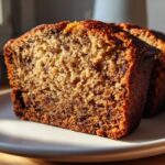Close-up of a moist slice of best banana bread showing a rich, dark crumb texture.