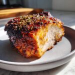 Close-up of a perfectly cooked, juicy slice of slow cooker turkey breast with a dark, herbed, and seasoned crust.