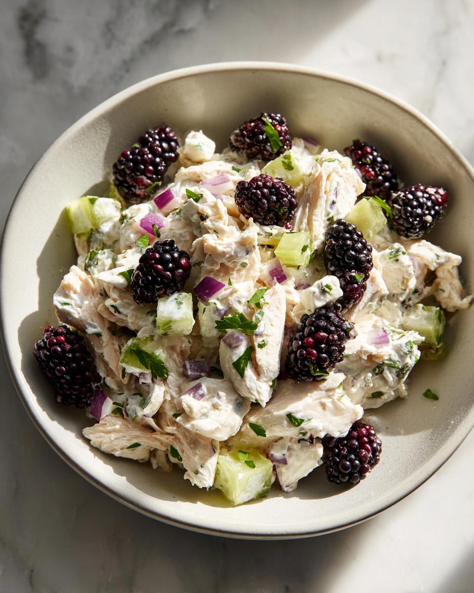 Close-up of low carb blackberry cottage cheese chicken salad with chunks of chicken, cucumber, and red onion.