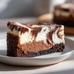 A rich slice of triple chocolate cheesecake with a marbled white and dark chocolate top layer.